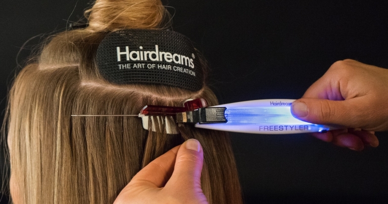 In the middle of the process of hair extension with bonding extensions with the Hairdreams FreeStyler