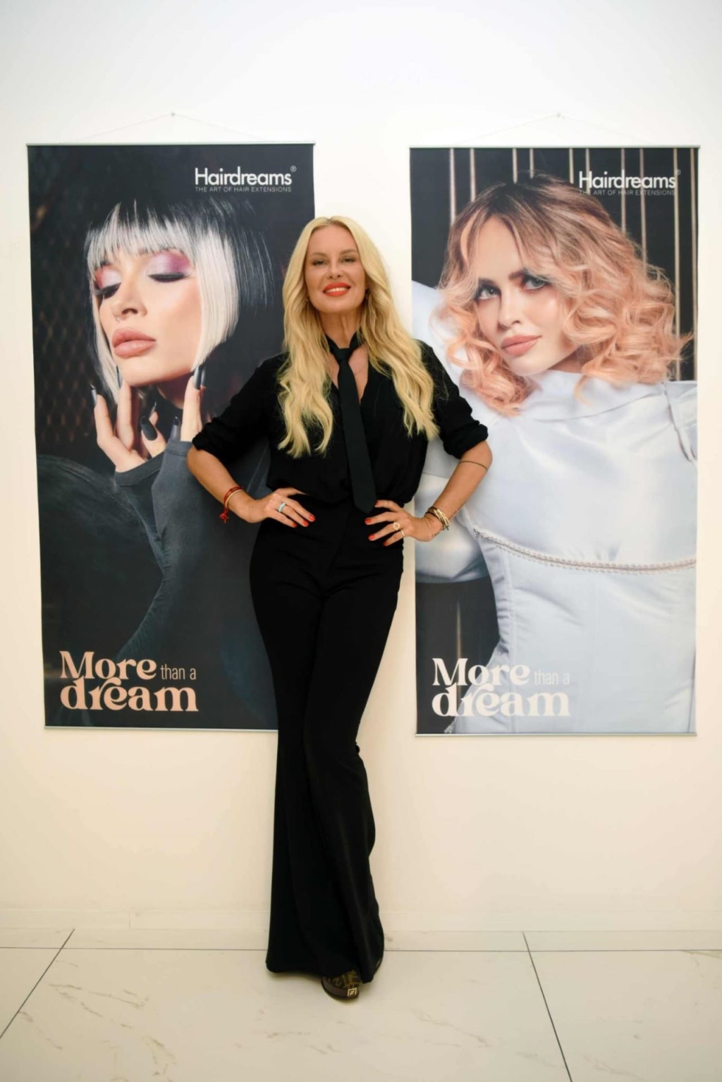 Woman with long blond hair poses in front of the posters of the campaign "More than a dream"