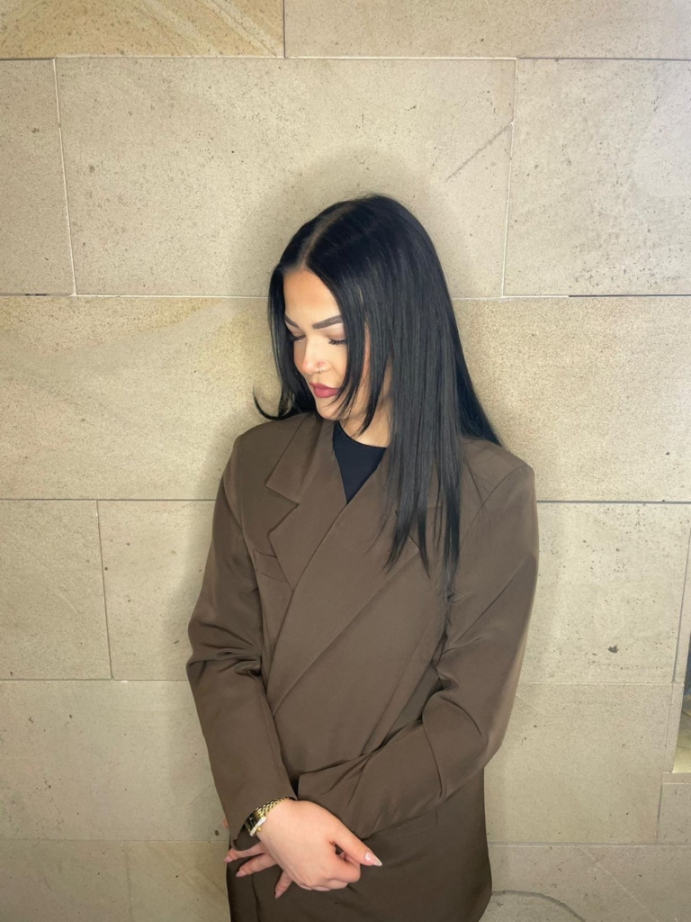 Woman with dark, shoulder-long hair looks on the ground