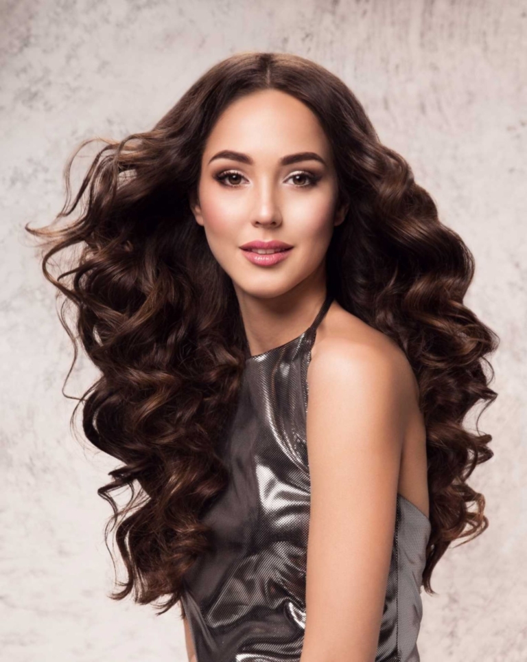 Brown-haired woman with curly hair and middle parting